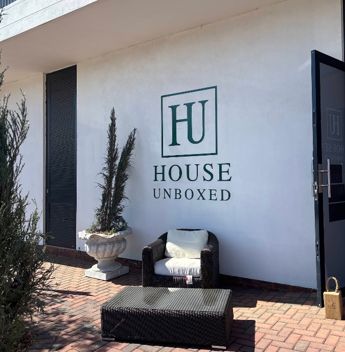 House Unboxed signage on the exterior wall with outdoor furniture below